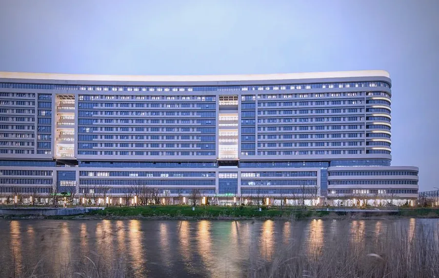 宁波杭州湾医院夜景外观，弧形主体建筑配套森科华净 4000 余台回风口空气净化装置